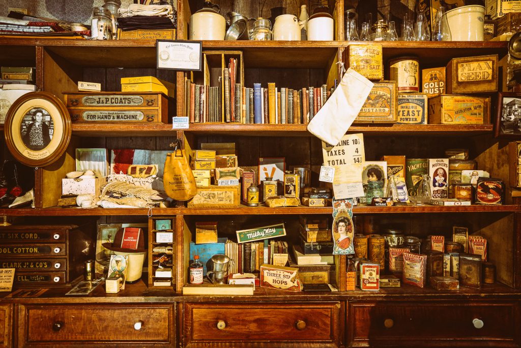Antique items on a cluttered bookshelf