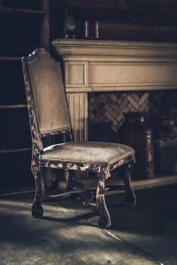 Antique wooden chair with fireplace in the background
