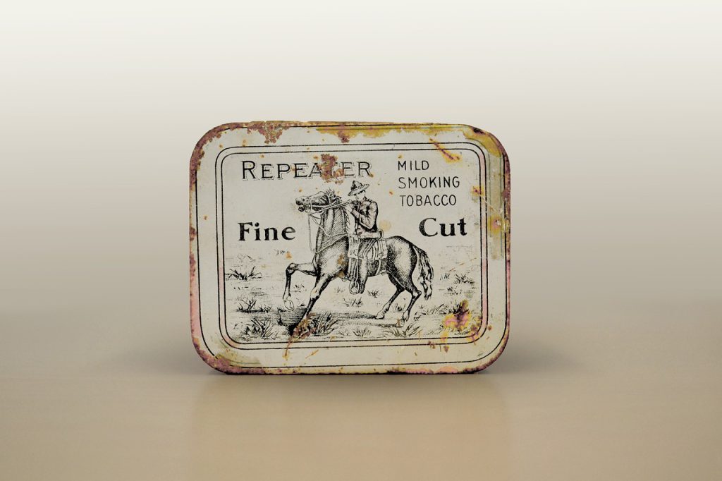 Antique tobacco tin against a neutral background