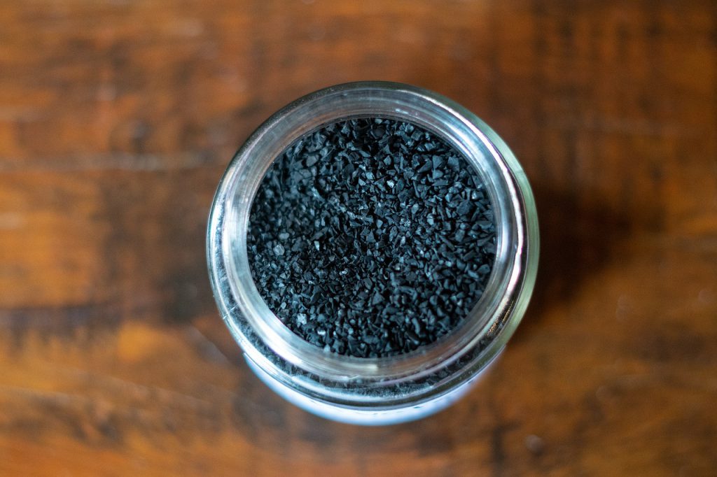 Cup of activated charcoal on a wooden surface