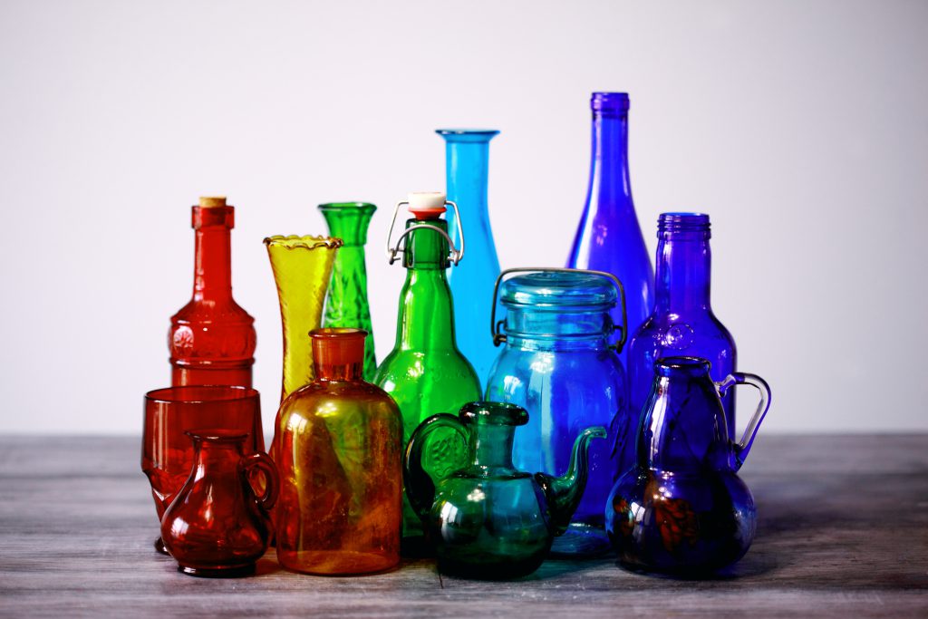 Red, green, and blue glass vessels on a table