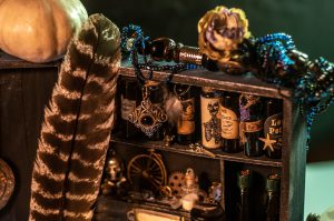 Closeup of small curio cabinet with spooky, gothic vials and items on the shelves