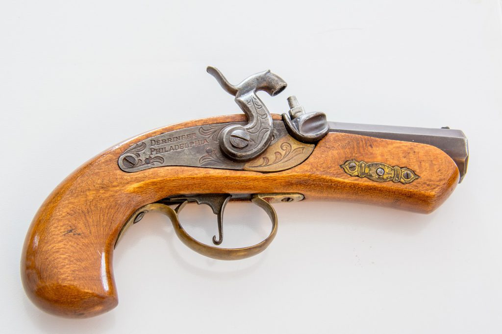 Small wooden antique gun with silver details