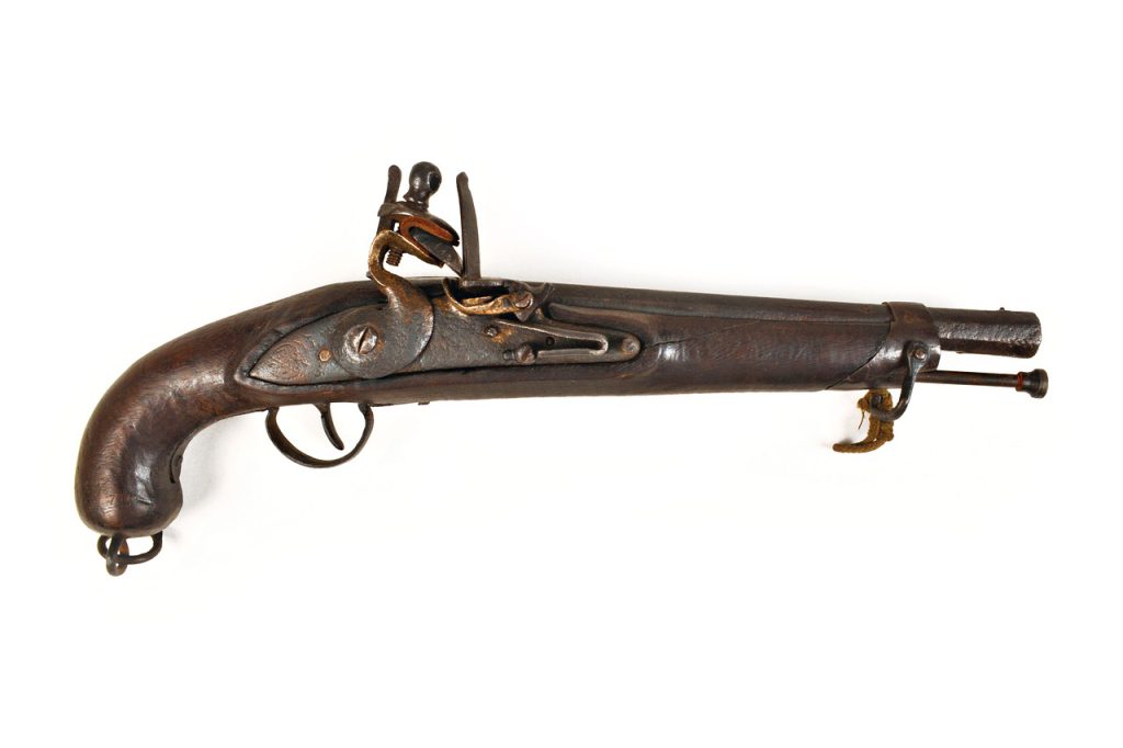 Antique metal firearm against a black background