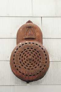 Rusted antique automatic sprinkler mounted on a wall