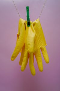Yellow cleaning gloves hanging from a clothesline