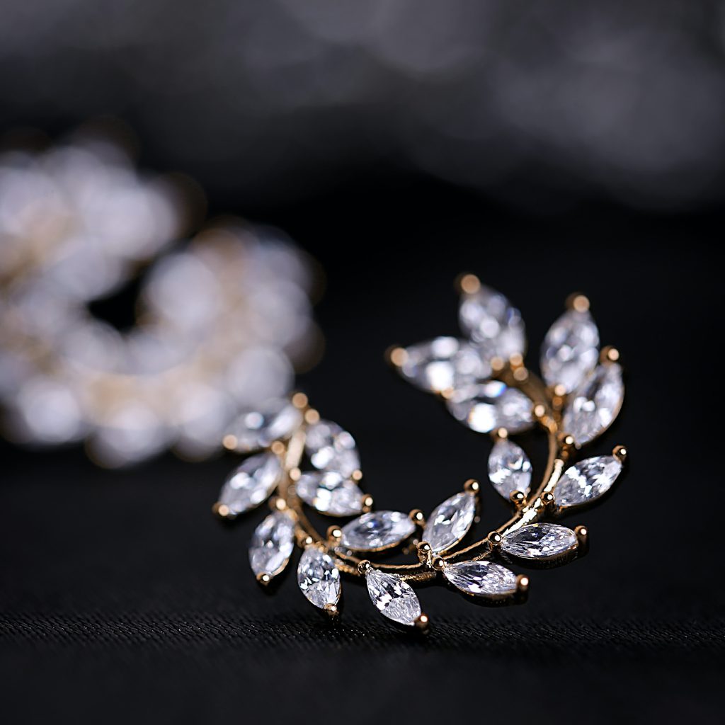 Closeup of a diamond earring in the shape of a laurel wreath