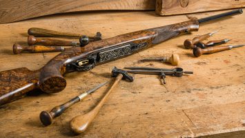 Antique rifle on a worktable surrounded by tools