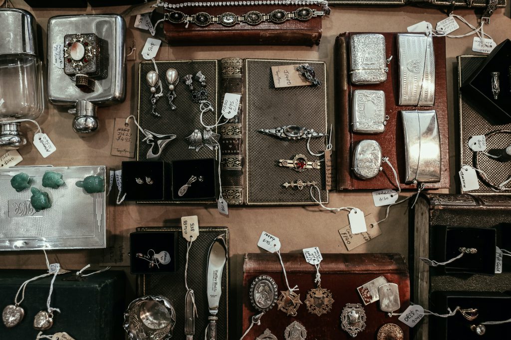 Jewelry and silver items displayed on a table in an antique store